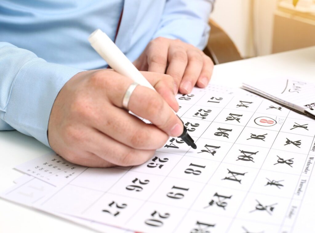 mężczyzna zaznaczający daty w kalendarzu